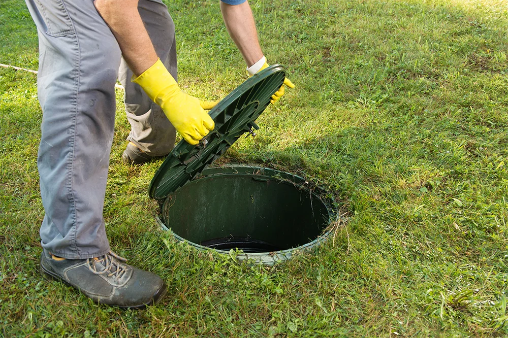 Opening septic tank lid. Cleaning and unblocking septic system and draining pipes