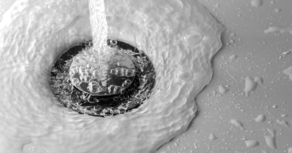 DrainCleaningPrevents_BlogImages_Blog_Website water pouring into a sink drain after drain cleaning